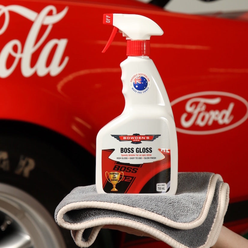 Bowser's Boss Gloss car care product on a gray towel with a red Ford vehicle in the background